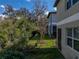 A view of the green backyard with a screened-in patio and nice landscaping at 6972 Ripple Pond Loop, Zephyrhills, FL 33541