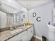 Well-lit bathroom featuring a double sink vanity with granite countertops and modern fixtures at 6972 Ripple Pond Loop, Zephyrhills, FL 33541