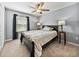 Bedroom with a bed, two side tables, a ceiling fan and a window with black curtains at 6972 Ripple Pond Loop, Zephyrhills, FL 33541