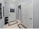 Entryway with light blue walls, a white door, tiled floor and black shoe rack at 6972 Ripple Pond Loop, Zephyrhills, FL 33541