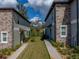 View of two townhomes with stone accents, green grass, and sidewalks leading to each front door at 6972 Ripple Pond Loop, Zephyrhills, FL 33541