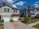 Well-maintained townhomes showcasing a stone accent wall, attached garages, and landscaped front yards in a community at 6972 Ripple Pond Loop, Zephyrhills, FL 33541