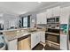 Modern kitchen featuring granite countertops, stainless steel appliances, and a seamless flow to the dining area at 6972 Ripple Pond Loop, Zephyrhills, FL 33541