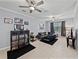 Living room with gray walls, tile floor, ceiling fan, and a black sectional sofa at 6972 Ripple Pond Loop, Zephyrhills, FL 33541