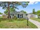 Gray house with blue door, driveway, and green lawn at 7234 12Th N St, St Petersburg, FL 33702