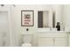 Clean bathroom with white vanity, shower, and vintage-style artwork at 9377 Runaway Breeze Dr, Land O Lakes, FL 34637