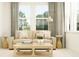 Light and airy living room with beige sofa and wooden coffee table at 9443 Runaway Breeze Dr, Land O Lakes, FL 34637