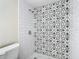 Bathroom with a patterned tile shower and white toilet at 10214 Turtle Hill Ct, Tampa, FL 33615