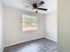 Bright bedroom with wood-look floors, ceiling fan, and window at 10214 Turtle Hill Ct, Tampa, FL 33615