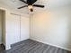 Bedroom with gray floors, ceiling fan and double-door closet at 10214 Turtle Hill Ct, Tampa, FL 33615