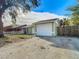 House exterior, featuring a light green facade and white garage door at 10214 Turtle Hill Ct, Tampa, FL 33615