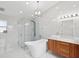 Modern bathroom with double sinks, a soaking tub and a glass shower at 11123 Elmhurst Dr, Pinellas Park, FL 33782