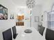 Modern dining room with white table and gray chairs, kitchen view at 11123 Elmhurst Dr, Pinellas Park, FL 33782