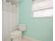 Clean bathroom with white toilet and shower, and light green walls at 11453 Imperial Grove E Dr, Largo, FL 33774