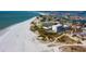 Aerial view of coastline, highlighting a beachfront building and white sand beach at 11730 Gulf Blvd # 49, St Petersburg, FL 33706