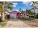 Pink house with garage and tropical landscaping at 129 Wall St, Redington Shores, FL 33708