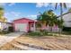 Pink house with garage and small yard at 129 Wall St, Redington Shores, FL 33708