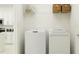 Bright laundry room with washer, dryer, and shelving for storage at 12968 Shining Blue Nile Ln, Parrish, FL 34219