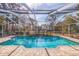 Relaxing screened-in swimming pool with a waterfall feature at 1454 Brigadier Dr, Spring Hill, FL 34608