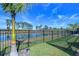 Private backyard with a lake view, lush lawn, and black metal fence at 14834 Paddock Pond Ave, Lithia, FL 33547