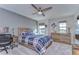 Cozy bedroom with a rustic bed, desk, and large windows at 14834 Paddock Pond Ave, Lithia, FL 33547