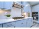 Modern kitchen features gas cooktop, white herringbone backsplash, and gray cabinets at 14834 Paddock Pond Ave, Lithia, FL 33547