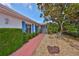 Welcoming front entry with red brick walkway and lush landscaping at 1807 Pineapple Palm Ct, Sun City Center, FL 33573