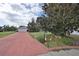 House with red brick driveway and landscaping at 1807 Pineapple Palm Ct, Sun City Center, FL 33573