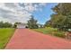 Single story home with red brick driveway and mature landscaping at 1807 Pineapple Palm Ct, Sun City Center, FL 33573