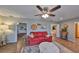 Bright living room features a red couch, wood floors and a view into the kitchen at 1807 Pineapple Palm Ct, Sun City Center, FL 33573