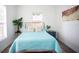 Comfortable bedroom with a teal bedspread and large windows at 1913 E Wilder Ave, Tampa, FL 33610