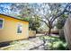 Yellow house exterior with a deck and large tree in the backyard at 1913 E Wilder Ave, Tampa, FL 33610