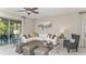 Bright and airy living room with white sectional sofa, gray accent chair, and large windows at 2001 Longliner Loop, Wesley Chapel, FL 33543