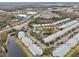 Aerial view of townhouses community near highway with pool and pond at 2552 Glenrise Pl, Wesley Chapel, FL 33544