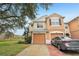 Two-story townhome with attached garage and brick driveway, located by a pond at 2552 Glenrise Pl, Wesley Chapel, FL 33544