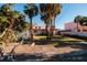 Spacious backyard with grassy area and mature palm trees at 3118 S Maritana Dr, St Pete Beach, FL 33706