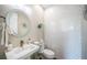 Elegant powder room with a modern sink, unique tile, and a decorative mirror at 335 Bath Club S Blvd, North Redington Beach, FL 33708