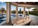 Relaxing outdoor lounge area with circular wicker daybed and views of the pool and water at 335 Bath Club S Blvd, North Redington Beach, FL 33708