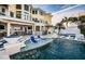 Luxury pool area with fire features, lounge chairs, and outdoor kitchen at 335 Bath Club S Blvd, North Redington Beach, FL 33708