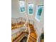 Elegant wooden staircase with modern metal railings and a stunning light fixture at 335 Bath Club S Blvd, North Redington Beach, FL 33708