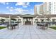 Outdoor BBQ area with tables, chairs, and modern building in the background at 450 Knights Run Ave # 415, Tampa, FL 33602