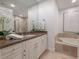 Elegant bathroom with granite countertop, soaking tub, and walk-in shower at 450 Knights Run Ave # 415, Tampa, FL 33602