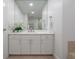 Bright bathroom with marble countertop and white cabinets at 450 Knights Run Ave # 415, Tampa, FL 33602