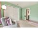 Charming bedroom with light green walls, a comfortable armchair, and built in closet at 4604 Westford Cir, Tampa, FL 33618