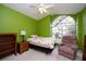 Bedroom with lime green walls, ceiling fan, and arched window at 5147 Sterling Manor Dr, Tampa, FL 33647