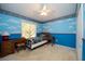 bedroom with blue walls, car themed bedding, and desk at 5147 Sterling Manor Dr, Tampa, FL 33647