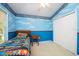 bedroom with blue walls, racecar bedding, and double door closet at 5147 Sterling Manor Dr, Tampa, FL 33647