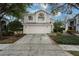 Two-story house with beige siding, attached garage, and landscaping at 5147 Sterling Manor Dr, Tampa, FL 33647