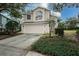 Two-story house with beige siding, attached garage, and landscaping at 5147 Sterling Manor Dr, Tampa, FL 33647