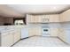 U-shaped kitchen with white cabinets and tile floor at 5147 Sterling Manor Dr, Tampa, FL 33647